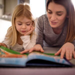 Maman passant du bon temps à lire à la maison avec son enfant